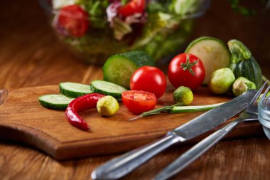 Taze sebze salatası ve olgun sebzeler üzerinde kesme ahşap arka plan üzerinde kurulu, seçici odak, yakın