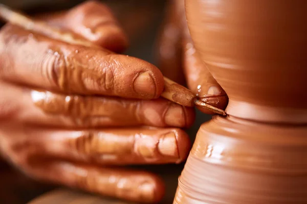 Close-up mãos de um oleiro masculino em avental fazendo um vaso de barro, foco seletivo — Fotografia de Stock