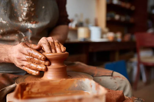 Nahaufnahme der Hände eines männlichen Töpfers in Schürze, der eine Vase aus Ton herstellt, selektiver Fokus — Stockfoto