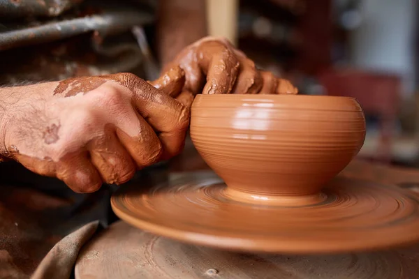 Крупным планом руки гончара в фартуке делают вазу из глины, избирательный фокус — стоковое фото