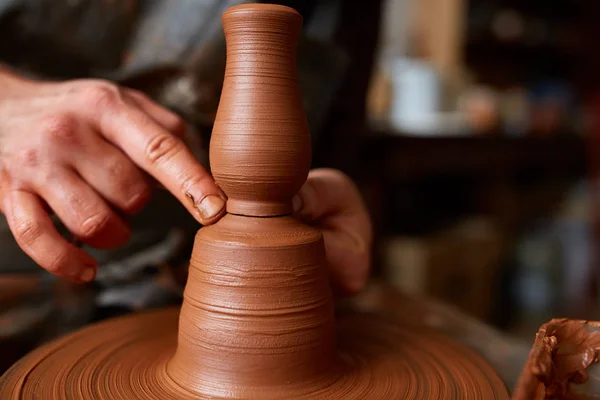 Nahaufnahme der Hände eines männlichen Töpfers in Schürze, der eine Vase aus Ton herstellt, selektiver Fokus — Stockfoto