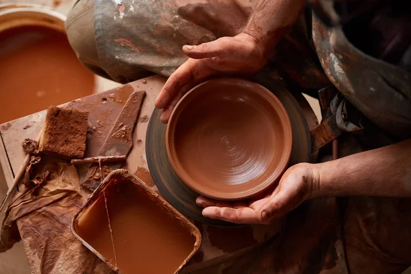 粘土、セレクティブ フォーカスから花瓶を作るエプロンの男性陶工のクローズ アップ手 — ストック写真