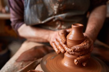 Yakın çekim eller erkek Potter Clay, seçici odak bir vazo yapma önlük