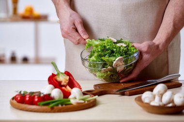 Adam seçici odak sağlıklı sebze salatası, yakın çekim, yapım mutfak yemek.