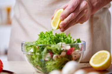 Adam seçici odak sağlıklı sebze salatası, yakın çekim, yapım mutfak yemek.