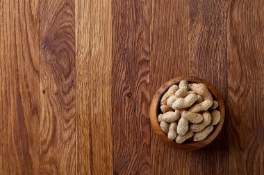 Ahşap kase rustik ahşap arka plan closeup, seçici odak içinde soyulmamış fıstık