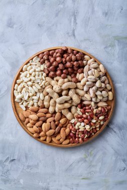 Beyaz arka plan, yakın çekim, en iyi görünüm, seçici odak ahşap tepsi üzerinde kahverengi kase karışık Kuruyemiş.