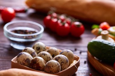 Taze yumurta bir bıldırcın Yeşiller ve sebze ahşap masa, seçici odak, yakın çekim