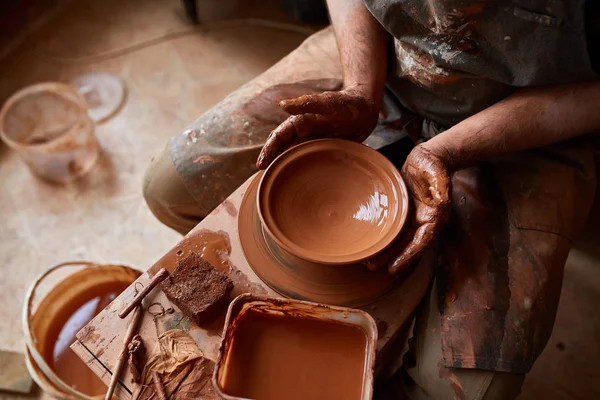 Portret van een mannelijke potter in schort mallen kom uit klei, selectieve aandacht, close-up — Stockfoto