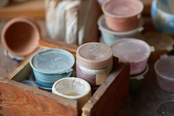 Close-up de várias canecas de pintura e pincéis em suporte na bancada, foco seletivo, vista lateral . — Fotografia de Stock