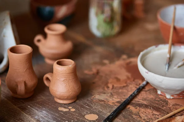 Primer plano de varias tazas de pintura y pinceles en el soporte en la encimera, enfoque selectivo, vista lateral . —  Fotos de Stock