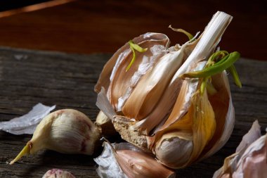 Sarımsak parçalar üzerinde karanlık kesme tahtası ahşap masa, sığ derinliği alan, seçici odak, makro yakın çekim