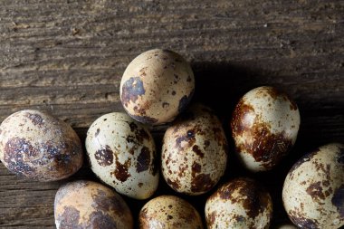 Seçici odak eski ahşap panoları, boşluk, arka plan üzerinde benekli bıldırcın yumurtası düzenlenmiş.