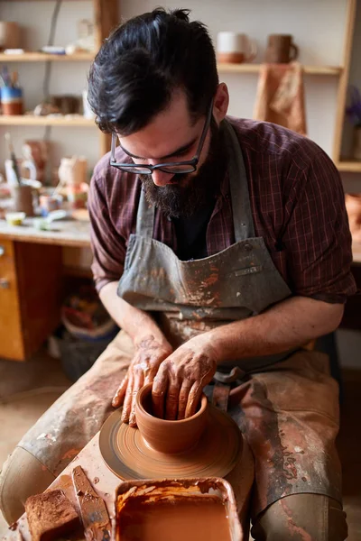 Portrét muže Potter v zástěře vymodeluje mísa z hlíny, selektivní fokus, detail — Stock fotografie