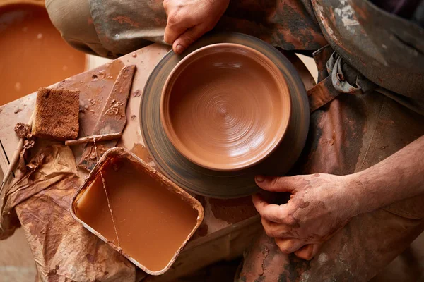 Close-up van de handen van een mannelijke potter in mallen schort kom uit klei, selectieve aandacht — Stockfoto