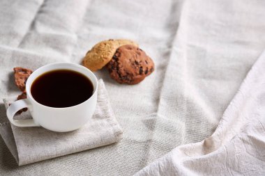 Kahve fincanı, kavanoz kahve çekirdekleri, Çerezler üzerinde saf masa örtüsü, seçici odak, yakın çekim, en iyi görünümü ile