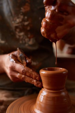 Yakın çekim eller erkek Potter Clay, seçici odak bir vazo yapma önlük
