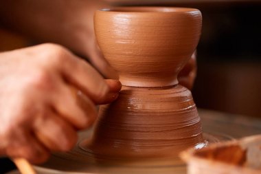 Çamurdan, seçici odak yakın çekim eller erkek Potter önlük kalıpları içinde kase