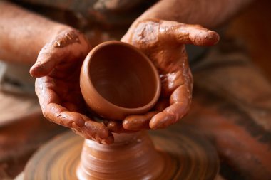 Çamurdan, seçici odak yakın çekim eller erkek Potter önlük kalıpları içinde kase