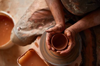 Çamurdan, seçici odak yakın çekim eller erkek Potter önlük kalıpları içinde kase