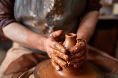 Çamurdan, seçici odak yakın çekim eller erkek Potter önlük kalıpları içinde kase