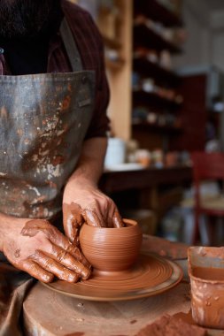 Bir erkek potter önlük portresi kase kil, seçici odak, yakın çekim kalıpları