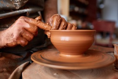 Çamurdan, seçici odak yakın çekim eller erkek Potter önlük kalıpları içinde kase