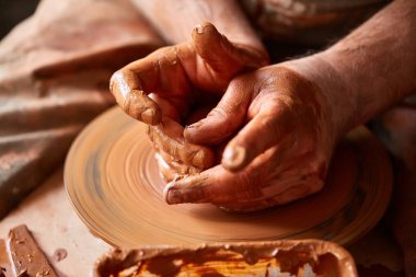 Çamurdan, seçici odak yakın çekim eller erkek Potter önlük kalıpları içinde kase