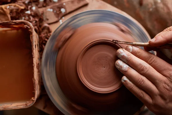 Vuxna manlig potter master modellering lera plattan på keramiker hjul. Ovanifrån, närbild, händerna bara. — Stockfoto
