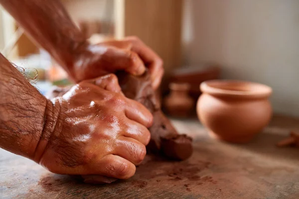 Mãos de oleiro macho moldando uma argila em oficina de cerâmica, close-up, foco seletivo — Fotografia de Stock