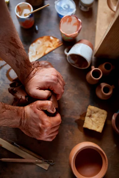 Руки чоловічих гончарів, що формують глину в керамічній майстерні, крупним планом, вибірковий фокус — стокове фото
