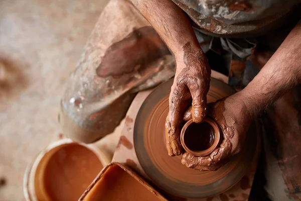 Närbild händerna på en manlig potter i förkläde formar skål från lera, selektivt fokus — Stockfoto
