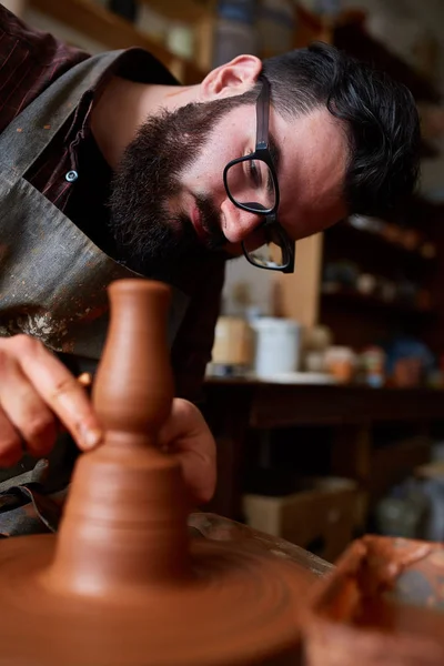 Portrét muže Potter v zástěře vymodeluje mísa z hlíny, selektivní fokus, detail — Stock fotografie