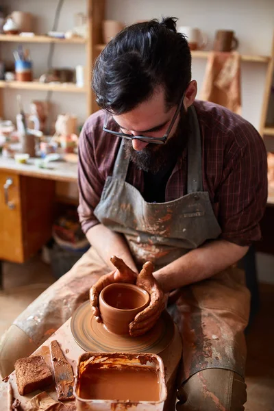 Portrét muže Potter v zástěře vymodeluje mísa z hlíny, selektivní fokus, detail — Stock fotografie