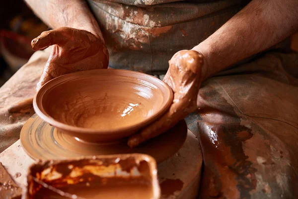 Close-up van de handen van een mannelijke potter in mallen schort kom uit klei, selectieve aandacht — Stockfoto