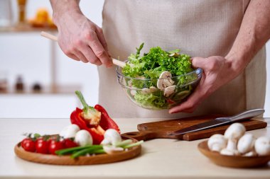 Adam seçici odak sağlıklı sebze salatası, yakın çekim, yapım mutfak yemek.