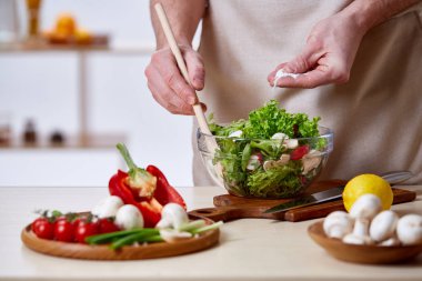 Adam seçici odak sağlıklı sebze salatası, yakın çekim, yapım mutfak yemek.