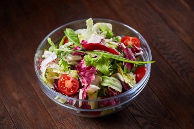 Cam kasede servis koyu ahşap arka plan, seçici odak, sığ derinlik-in tarla üzerinde taze sebze salatası