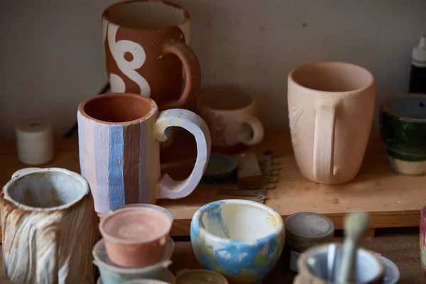 Primer plano de varias tazas de pintura y pinceles en el soporte en la encimera, enfoque selectivo, vista lateral . —  Fotos de Stock