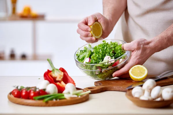 Adam seçici odak sağlıklı sebze salatası, yakın çekim, yapım mutfak yemek.