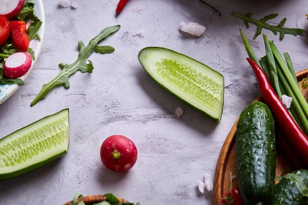 Yaratıcı taze sebze salatası ruccola, salatalık, domates ve beyaz plaka, seçici odak üzerinde raddish
