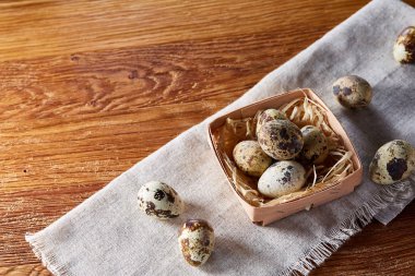 Rustik ahşap masa, yakın çekim, yüksek açılı görünüş, seçici odak kapsayıcısında bıldırcın yumurtası.