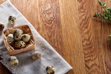 Rustik ahşap masa, yakın çekim, yüksek açılı görünüş, seçici odak kapsayıcısında bıldırcın yumurtası.