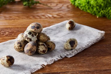 Piramit peçeteye düzenlenen bir ahşap masa, yakın çekim, seçici odak üzerinde bıldırcın yumurtası.