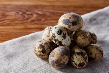 Piramit peçeteye düzenlenen bir ahşap masa, yakın çekim, seçici odak üzerinde bıldırcın yumurtası.