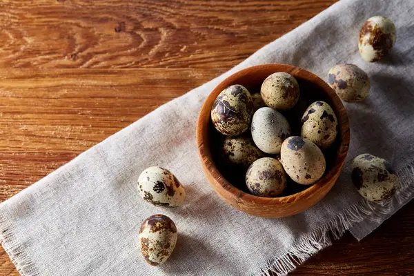 Cuenco con huevos de codorniz, huevos en una servilleta hecha en casa en la mesa de madera, primer plano, enfoque selectivo — Foto de Stock