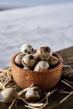 Ahşap kase bıldırcın yumurtası ahşap tahta üzerinde dolu beyaz arka plan, yakın çekim, seçici odak üzerinde.