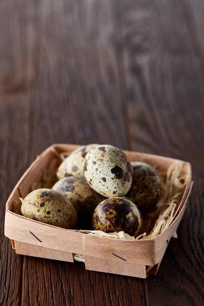 Quail eggs in a box on a rustic wooden background, top view, selective focus, vertical — Stock Photo, Image