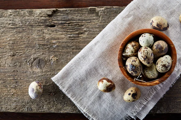 Cuenco con huevos de codorniz, huevos en una servilleta hecha en casa sobre fondo de madera, primer plano, enfoque selectivo — Foto de Stock