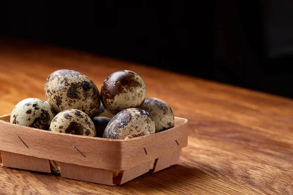 Quail eggs in a box on a rustic wooden background, top view, selective focus. — Stock Photo, Image